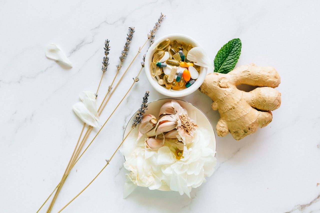 gallery-01 Flat lay of ginger, garlic, flowers, and supplements for holistic health.