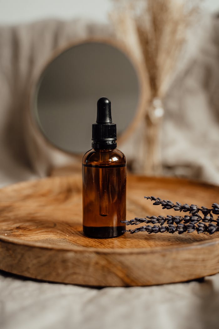 services-02 Amber glass dropper bottle on a wooden tray with lavender, ideal for skincare presentations.